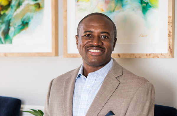 Lincolnton Family Dentistry | Smiling dentist seated in front of colorful abstract artwork